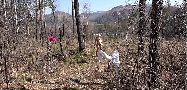  Fusion with nature in the outdoors. Blonde with a big ass strips in the forest and with a bare natural hairy pussy playing with a spruce twig.